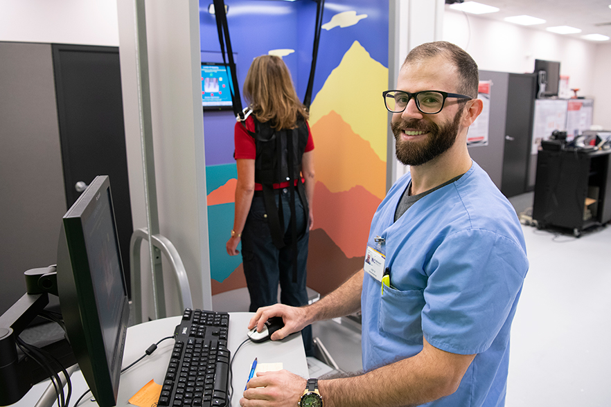 Joseph Barron stands by a computer in the Human Performance and Biodynamics Motion Lab