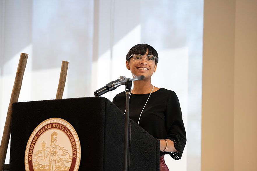 Student stands behind podium at summit.