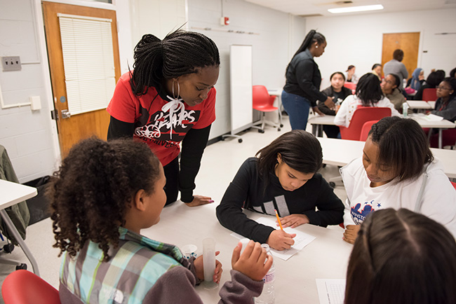 Camp youth women writing as a group during an activity