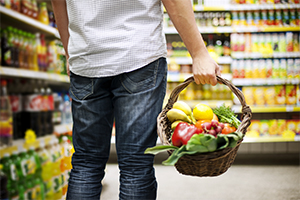 a grocery shopper carrying produce in a basket